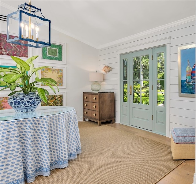 122 Saint Andrews Dr, Saint Simons Island, GA 31522 - entrance foyer featuring vaulted ceiling, ornamental molding, wood walls, and wood finished floors