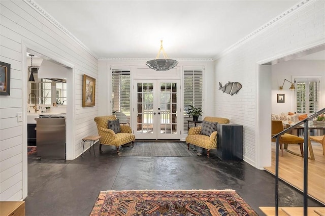 living area featuring crown molding, finished concrete flooring, french doors, and a wealth of natural light