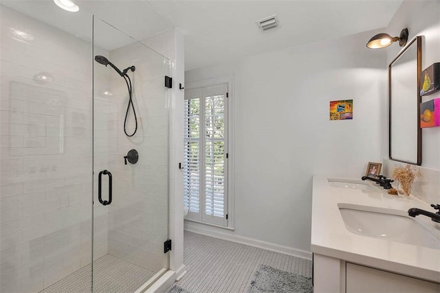 bathroom featuring tile patterned flooring, visible vents, a stall shower, and a sink