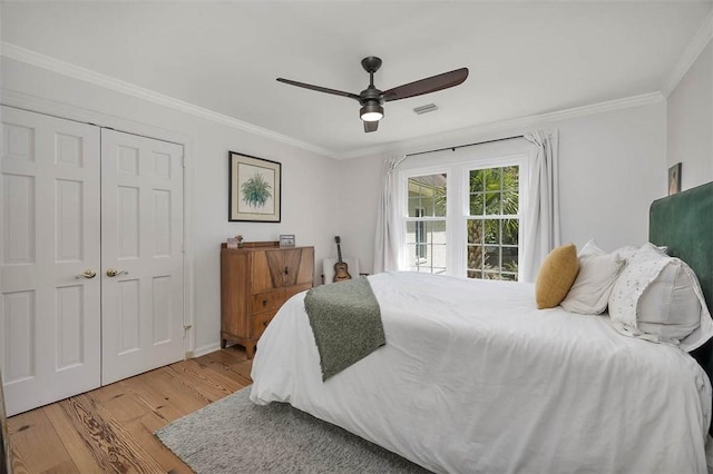 bedroom with ceiling fan, visible vents, wood finished floors, and ornamental molding