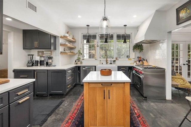 kitchen featuring visible vents, light countertops, custom exhaust hood, stainless steel appliances, and a sink