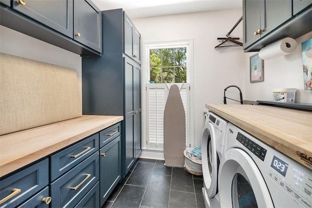 laundry room with dark tile patterned flooring, cabinet space, and washer and clothes dryer