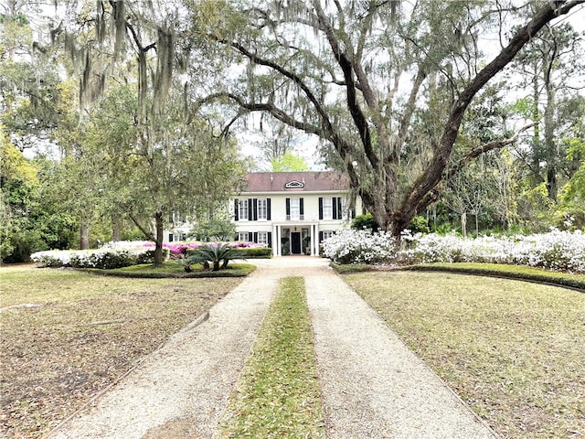 colonial inspired home with a front lawn and driveway