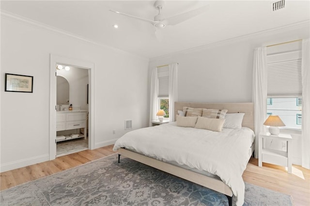 bedroom with hardwood / wood-style flooring, crown molding, sink, and connected bathroom