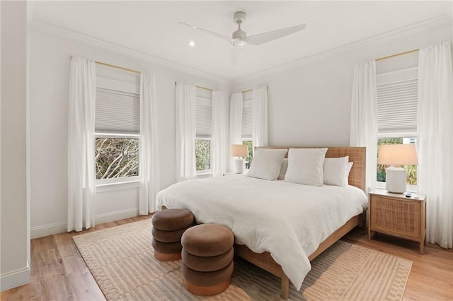 bedroom with crown molding, ceiling fan, and light hardwood / wood-style floors