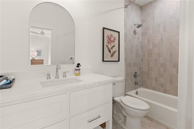 full bathroom featuring tiled shower / bath combo, vanity, and toilet