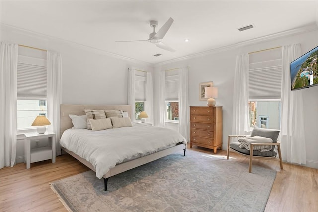 bedroom with crown molding, wood-type flooring, and ceiling fan