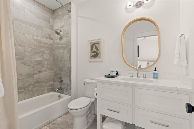 full bathroom featuring tiled shower / bath, vanity, and toilet