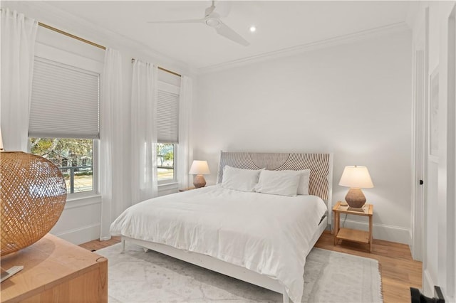 bedroom featuring crown molding, ceiling fan, and light hardwood / wood-style flooring