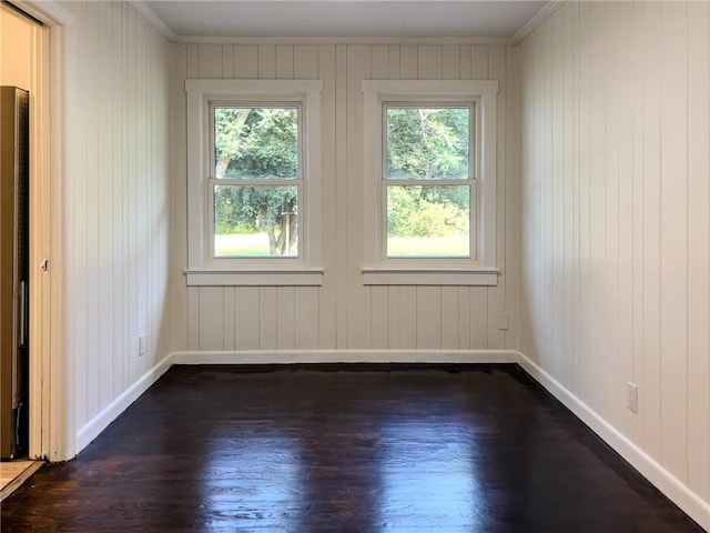 4166 Southern Rd, Brunswick, GA 31520 - empty room with healthy amount of natural light, dark wood-style floors, crown molding, and wood walls