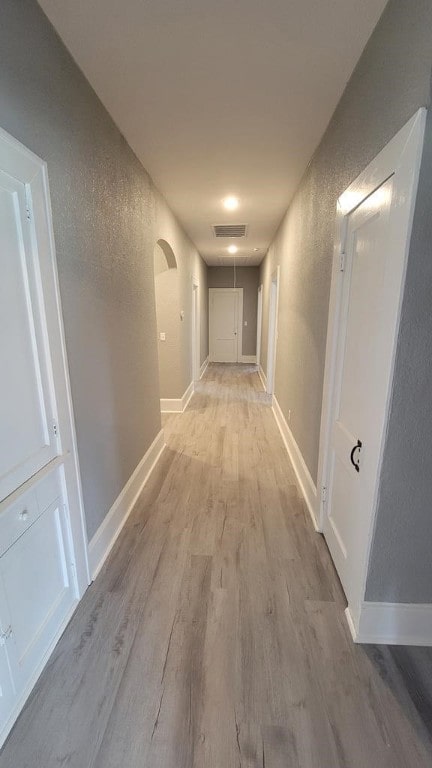 506 Ware St, Waycross, GA 31501 - hallway featuring light wood-style flooring, arched walkways, and a textured wall