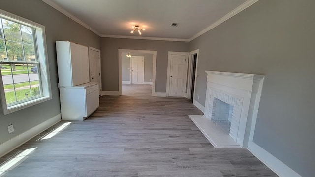 506 Ware St, Waycross, GA 31501 - unfurnished living room featuring healthy amount of natural light, crown molding, light wood-style floors, and a fireplace