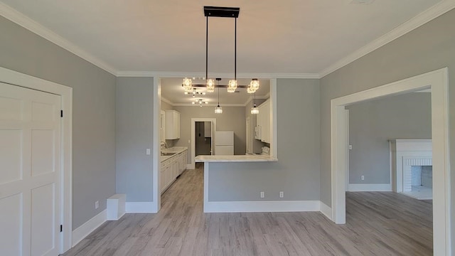 506 Ware St, Waycross, GA 31501 - kitchen with crown molding, freestanding refrigerator, light countertops, white cabinets, and light wood-type flooring
