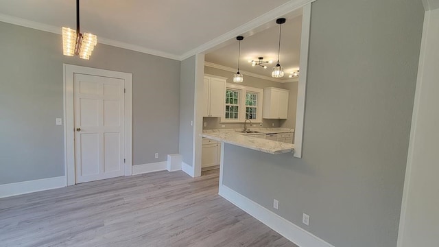 506 Ware St, Waycross, GA 31501 - kitchen with a chandelier, crown molding, white cabinets, light wood-style floors, and hanging light fixtures