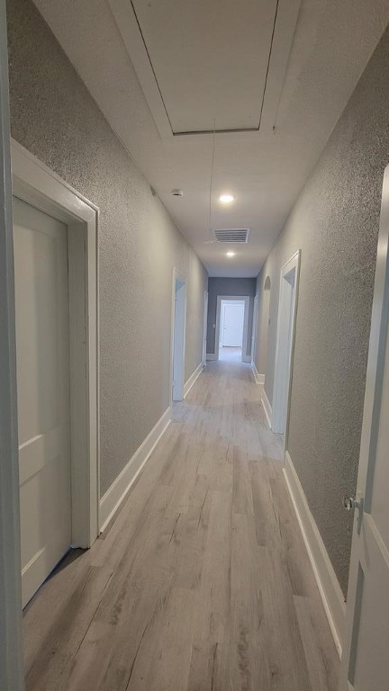 506 Ware St, Waycross, GA 31501 - hallway with attic access, a textured wall, and light wood-style flooring