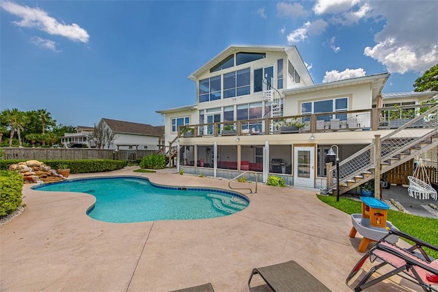 view of pool with a sunroom and a patio area