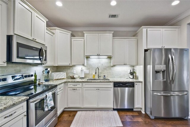 kitchen featuring appliances with stainless steel finishes, dark hardwood / wood-style floors, white cabinetry, and sink