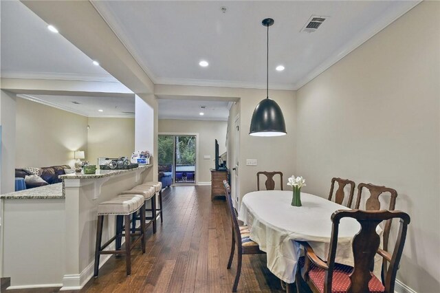 dining room with crown molding and dark wood-type flooring