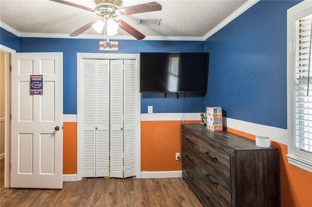 265 Traders Hill Rd, Folkston, GA 31537 - bedroom featuring a closet, wood finished floors, ornamental molding, a textured ceiling, and visible vents