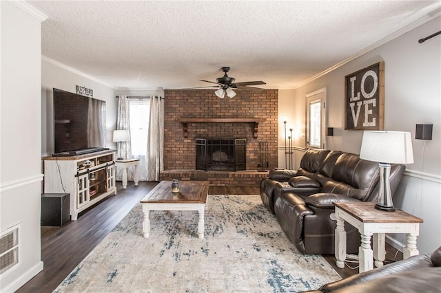 265 Traders Hill Rd, Folkston, GA 31537 - living room with wood finished floors, a ceiling fan, a fireplace, a textured ceiling, and visible vents