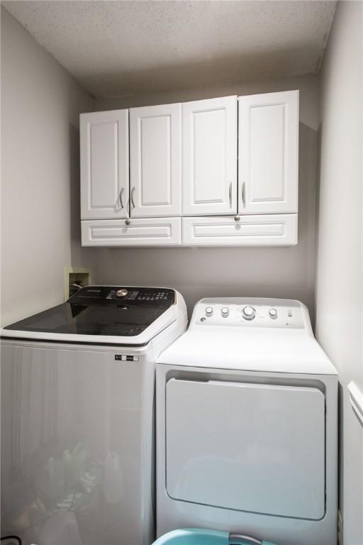 265 Traders Hill Rd, Folkston, GA 31537 - laundry room featuring cabinet space, a textured ceiling, and separate washer and dryer