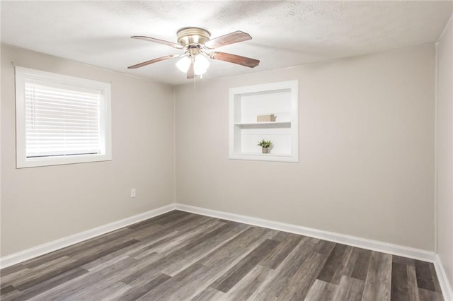 1348 Crestridge Rd, Waycross, GA 31503 - spare room with dark wood-style floors, built in shelves, and a ceiling fan