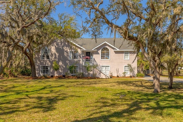 view of front facade featuring a front lawn and stairway