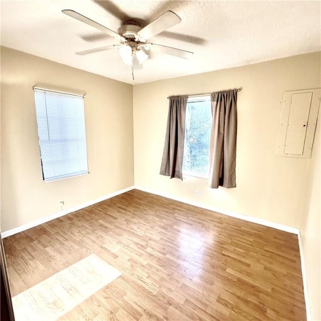 1110 Waller St, Waycross, GA 31501 - spare room featuring a ceiling fan, wood finished floors, baseboards, electric panel, and a textured ceiling