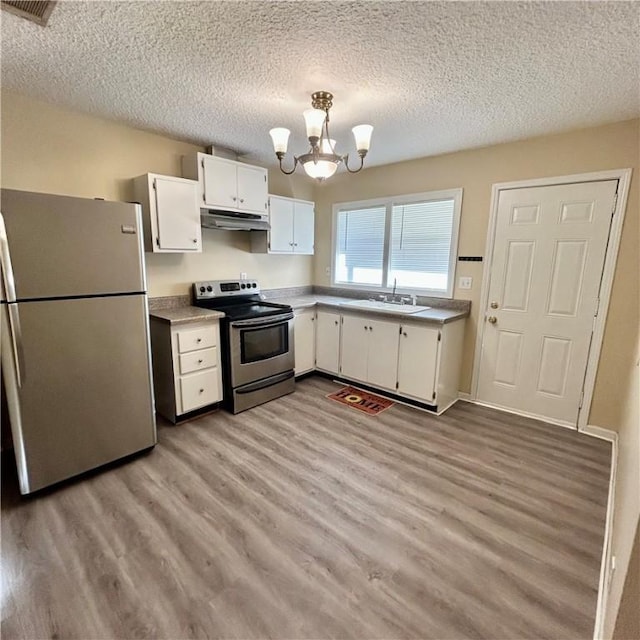 1110 Waller St, Waycross, GA 31501 - kitchen with a chandelier, appliances with stainless steel finishes, light wood-style floors, white cabinets, and a sink