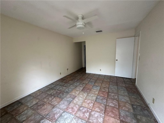 spare room with a ceiling fan, baseboards, and visible vents
