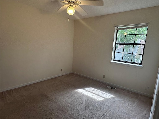 empty room with visible vents, a ceiling fan, carpet, and baseboards