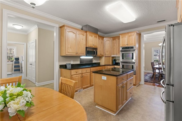 kitchen featuring a kitchen island, ornamental molding, plenty of natural light, and appliances with stainless steel finishes