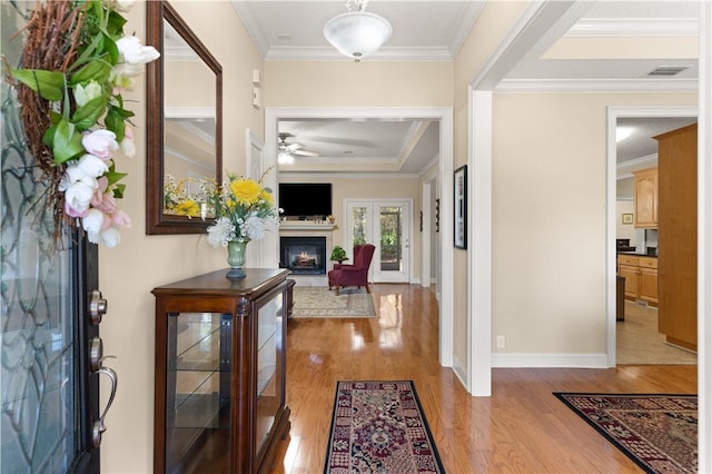 foyer featuring light hardwood / wood-style floors, crown molding, and ceiling fan