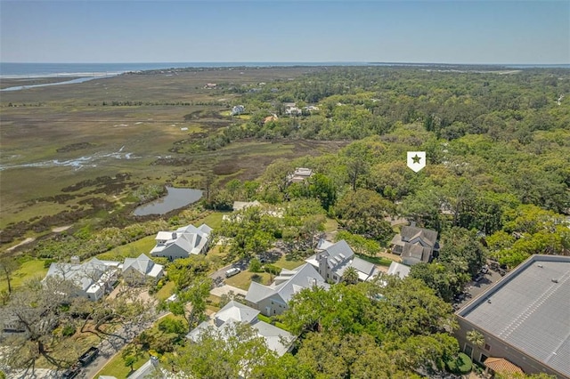 drone / aerial view featuring a view of trees, a water view, and a residential view