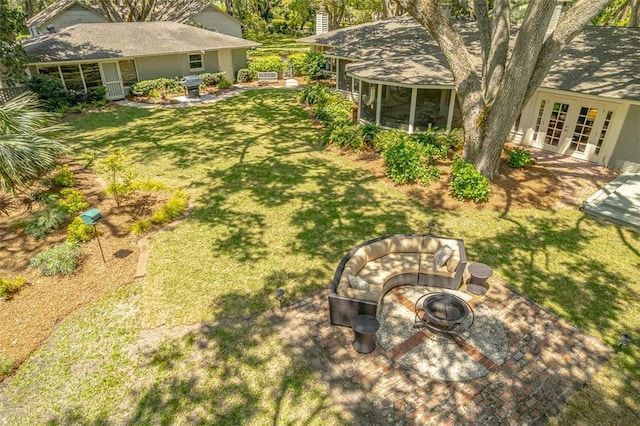 view of yard featuring a sunroom, an outdoor fire pit, french doors, and a patio area