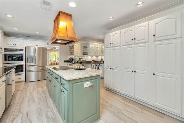 kitchen with white cabinets, green cabinetry, stainless steel appliances, a kitchen island, and custom range hood