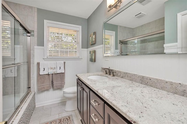 bathroom with wainscoting, tile patterned floors, vanity, and toilet
