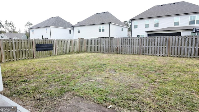 view of yard featuring a fenced backyard and a residential view