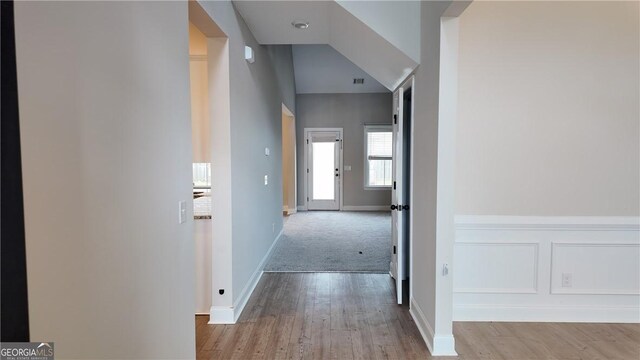 corridor with visible vents, baseboards, and wood finished floors