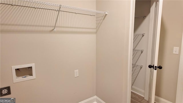 clothes washing area featuring hookup for an electric dryer, laundry area, baseboards, and hookup for a washing machine