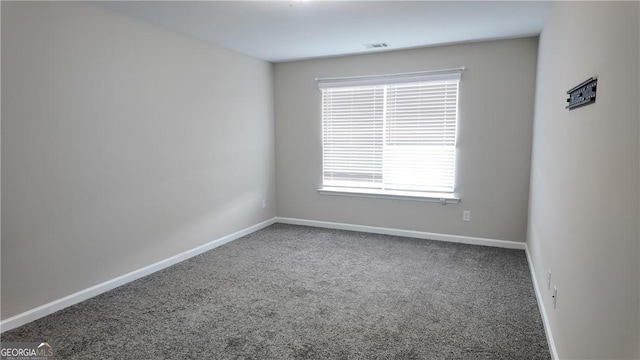 carpeted empty room featuring a healthy amount of sunlight, baseboards, and visible vents