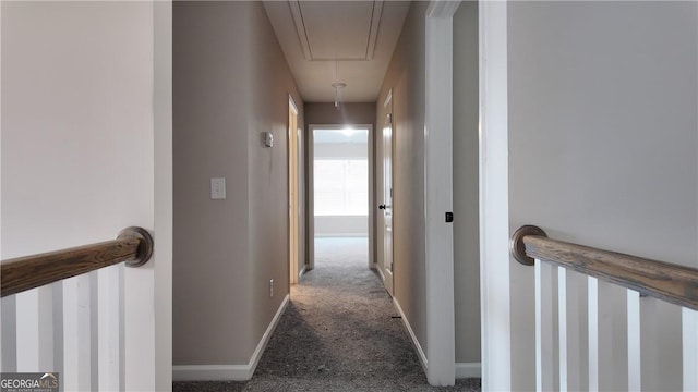 hall with carpet flooring, baseboards, an upstairs landing, and attic access