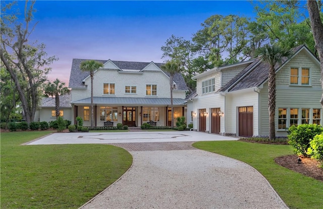 329 Saint Annies Ln, Saint Simons Island, GA 31522 - view of front of home with gravel driveway, a porch, a front yard, and an attached garage