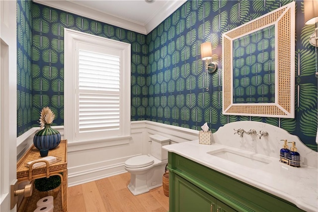 329 Saint Annies Ln, Saint Simons Island, GA 31522 - bathroom with wallpapered walls, wood finished floors, ornamental molding, a wainscoted wall, and vanity