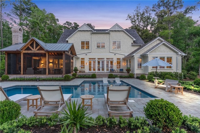 329 Saint Annies Ln, Saint Simons Island, GA 31522 - rear view of property featuring a patio, a sunroom, and an outdoor pool