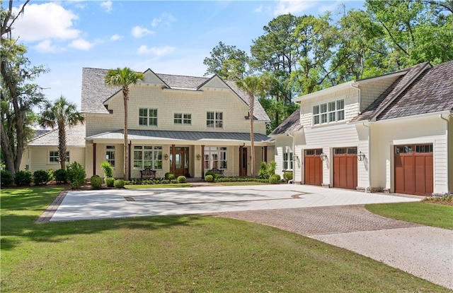 329 Saint Annies Ln, Saint Simons Island, GA 31522 - shingle-style home with decorative driveway, a front lawn, a garage, and a standing seam roof