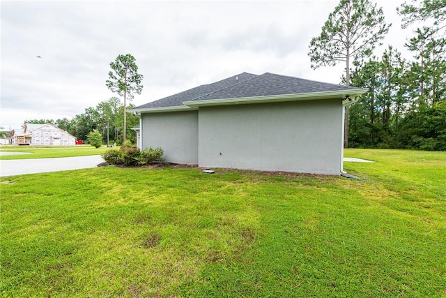 119 Silver Bluff Dr, Brunswick, GA 31523 - view of side of property with a lawn, a shingled roof, and stucco siding