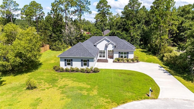 119 Silver Bluff Dr, Brunswick, GA 31523 - view of front facade featuring concrete driveway, stucco siding, a front lawn, and roof with shingles