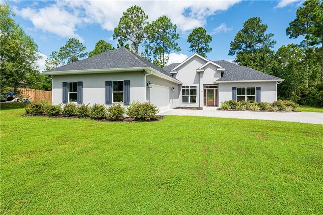 119 Silver Bluff Dr, Brunswick, GA 31523 - view of front of home with stucco siding, an attached garage, and concrete driveway