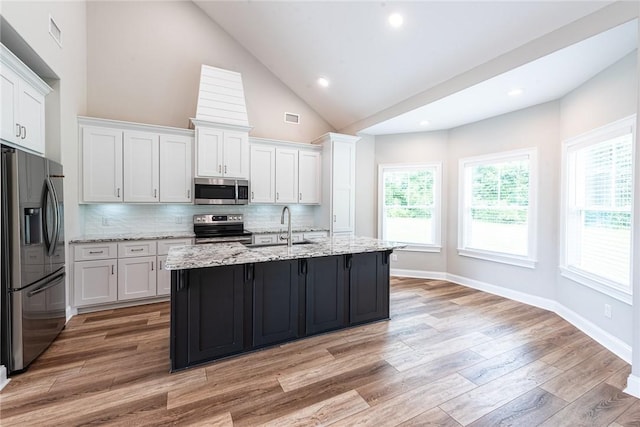 119 Silver Bluff Dr, Brunswick, GA 31523 - kitchen with stainless steel appliances, white cabinets, light wood-style floors, backsplash, and plenty of natural light